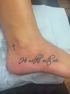 a person with a tattoo on their foot that says, he who walks with me