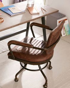 an office chair sitting in front of a desk with a potted plant on it