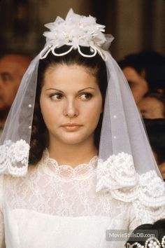 a woman in a wedding dress with a veil over her head