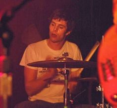 a man sitting in front of a drum set