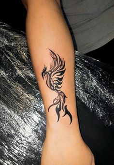 a woman's foot with a bird tattoo on the left side of her leg