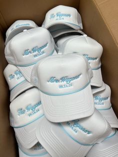 a box full of white hats with the words mr morgan in blue lettering on them