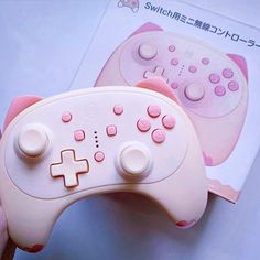 a close up of a person holding a nintendo wii game controller in their left hand