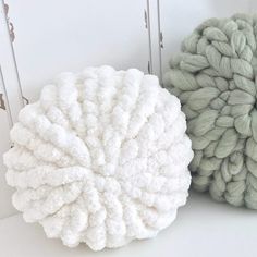 two balls of yarn sitting next to each other on top of a white countertop