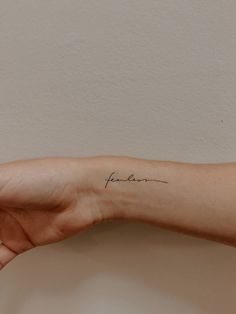 a person's arm with a small tattoo on the left side of their arm