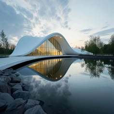 a building that is next to a body of water with rocks in front of it