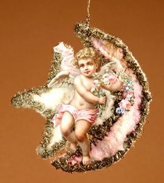 a christmas ornament with an angel sitting on the moon