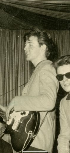 an old black and white photo of two men playing guitars