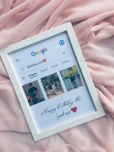 a photo frame sitting on top of a bed covered in pink sheets with photos and words