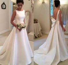 a woman in a white wedding dress standing next to a mirror