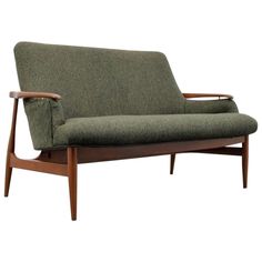 a green couch sitting on top of a wooden frame