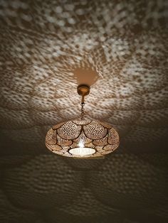 a chandelier hanging from the ceiling in a dark room with spots on it