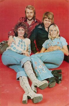 four people sitting on the ground posing for a photo