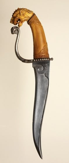 a knife with a wooden handle attached to it's side and the blade is shaped like a horse head