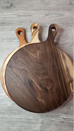 two wooden cutting boards sitting on top of a table