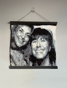 an image of two people hanging on a wall with a black and white photo in the background