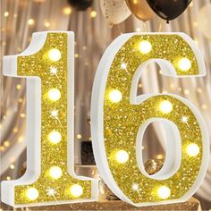 a close up of a number with balloons in the background