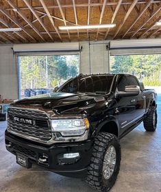 a large black truck parked in a garage