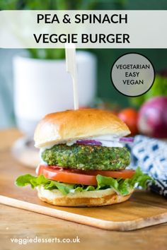 a veggie burger on a cutting board with the words pea & spinach veggie burger