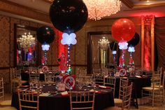 a banquet hall decorated with black, white and red balloons for an elegant event centerpiece