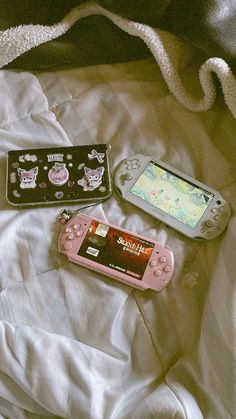 three electronic devices sitting on top of a bed