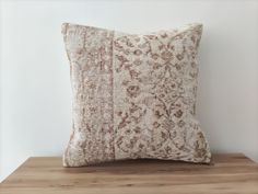 a brown and white pillow sitting on top of a wooden table