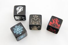 four dices with different designs on them sitting next to each other in front of a white background