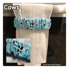 two pieces of cloth hanging from the side of a microwave oven door, with an image of cows on it