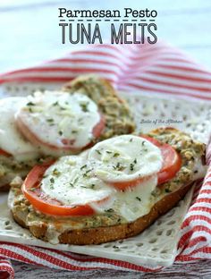 an open faced sandwich with tomatoes and cheese on it sitting on a white plate next to a red and white striped napkin