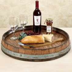 wine, bread and cheese are sitting on a barrel