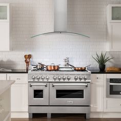 a stove top oven sitting inside of a kitchen next to an oven with pots and pans on it