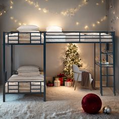 there is a bunk bed with lights on the ceiling and a christmas tree next to it