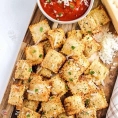 breaded croutons with parmesan cheese and tomato sauce on a cutting board