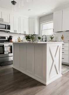 a kitchen with white cabinets and an island