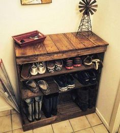 a wooden shelf with shoes and umbrellas on it in the corner of a room