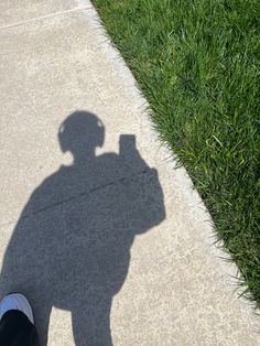 the shadow of a person standing on a sidewalk