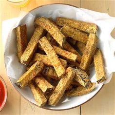 a bowl filled with fried french fries next to some ketchup