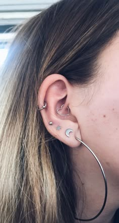 a close up of a person with ear piercings on their ears and behind them is a window