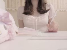 a woman sitting at a table with a pen in her hand