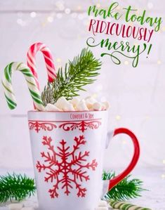 a mug filled with marshmallows and candy canes