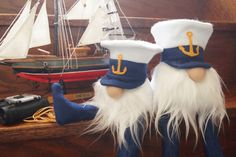 two gnomes are standing next to each other in front of a boat