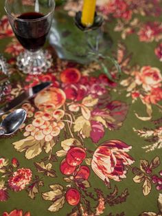 a table topped with glasses and silverware on top of a floral covered table cloth