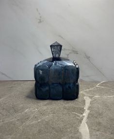 a blue vase sitting on top of a marble counter next to a white wall and floor