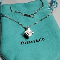 Tiffany & Co. Atlas Cube Roman Numerals Necklace Pendant. Discontinued Tiffany Necklace 16" Long, Comes With Tiffany & Co. Pouch Displayed In Pictures . Elegant Formal Necklace With Logo Charm, Formal Necklaces With Logo Charm, Silver Jewelry With Logo Charm For Anniversary, Pendant Necklace With Logo Charm For Gift, Sterling Silver Necklace With Logo Charm, Logo Charm Pendant Necklace For Gift, Anniversary Silver Jewelry With Logo Charm, Designer Sterling Silver Necklace Gift, Silver Jewelry With Logo Charm For Gift