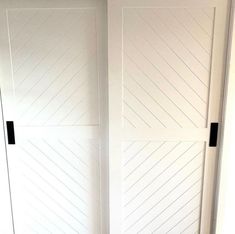 two white doors with black handles in a room