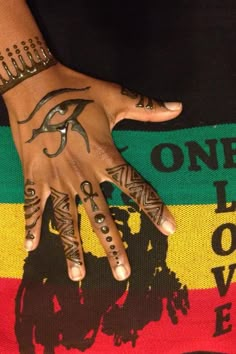 a person's hand with tattoos on it and one eye painted on the palm