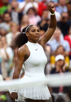 a female tennis player raising her arm in the air