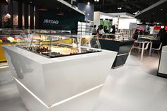 an empty counter in a restaurant with people standing around