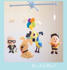 three stuffed animals hanging from a mobile in the shape of children's play toys