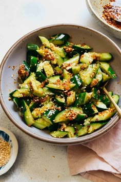 a bowl filled with cucumbers and topped with sesame seeds